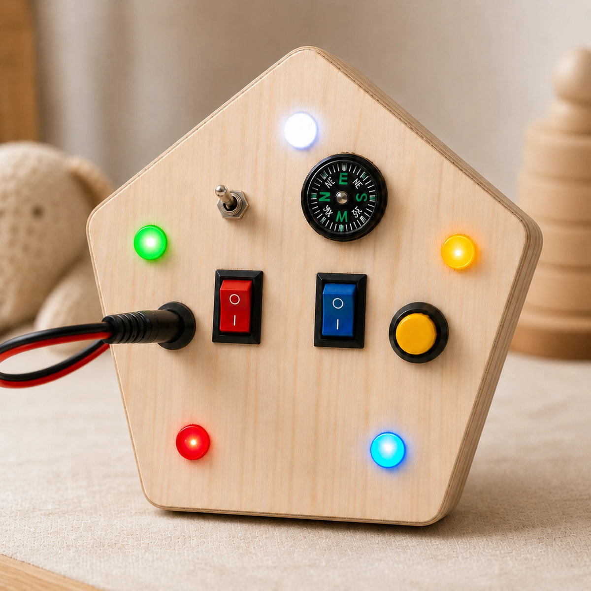 Close-up of RedMonkys wooden busy board with glowing LED lights, switches, push button and compass